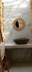 a bathroom with a stone sink on a counter at Mahatva Borobudur Resort in Borobudur +18 photos