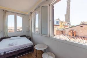 a bedroom with a bed and two windows at Asinelli, Bologna by Short Holidays in Bologna