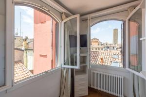 a balcony with two windows and a view of the city at Asinelli, Bologna by Short Holidays in Bologna