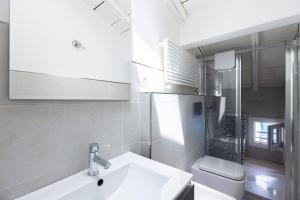 a white bathroom with a sink and a toilet at Asinelli, Bologna by Short Holidays in Bologna +17 photos