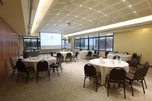 a conference room with tables and chairs and a projection screen at Lancaster Tamar Hotel- Hadath in Beirut +34 photos