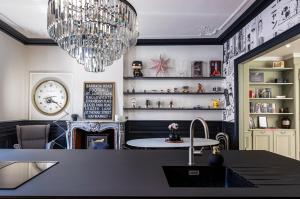 a dining room with a chandelier and a table at Le Duval 66 in Pontarlier