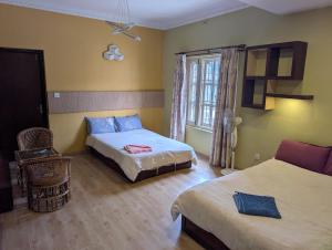 a hotel room with two beds and a window at Heritage View Homestay, Kathmandu in Kathmandu