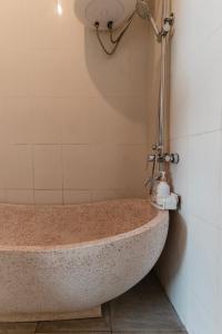 a bath tub with a shower in a bathroom at oemah samiya in Keramas