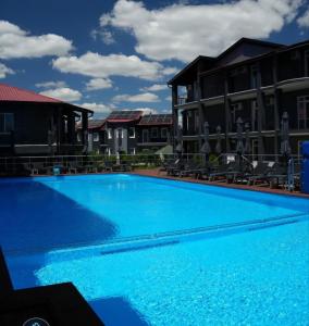 a large blue swimming pool with buildings in the background at Sea Cloud Hotel in Zatoka