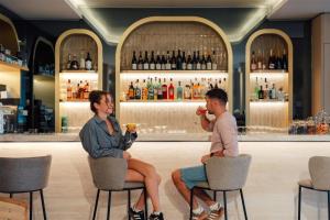 two people sitting in chairs at a bar at Radisson Hotel Cannes Seaside in Cannes