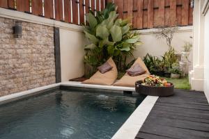 a small swimming pool with cushions next to a house at oemah samiya in Keramas +15 photos