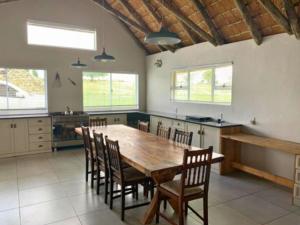 a large kitchen with a wooden table and chairs at The Boathouse in Harrismith +8 photos