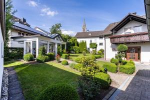 a yard with a white house with a garden at Ferienwohnung Kleine Auszeit in Eslohe