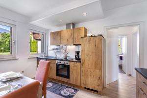a kitchen with white walls and wooden cabinets at Ferienwohnung Kleine Auszeit in Eslohe