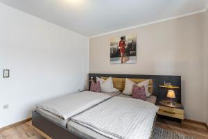 a bedroom with a bed with white and purple pillows at Ferienwohnung Kleine Auszeit in Eslohe