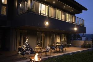 a house with a patio with chairs and a table at STARRY Residence Suite Hakuba Happo-one in Hakuba