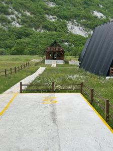 a building in the middle of a field with a fence at Komarnica Forest Owl 3 in Šavnik +29 photos