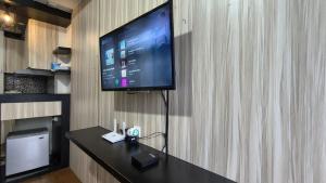 a flat screen tv on a wall in a room at Malioboro City Apartement by Dev's Room in Seturan