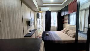 a bedroom with a bed and a television in it at Malioboro City Apartement by Dev's Room in Seturan +22 photos