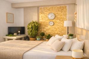 a bedroom with a large bed and clocks on the wall at Durres Sun & Sea Luxury Apartment in Durrës +16 photos