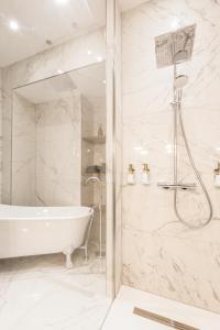 a white bathroom with a tub and a shower at Le Duval 66 in Pontarlier +12 photos