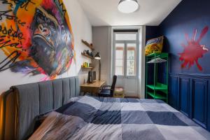 a bedroom with a bed and a painting on the wall at Le Duval 66 in Pontarlier