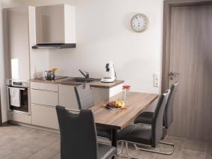 a kitchen with a table and chairs and a clock on the wall at Bantlehof in Niedereschach