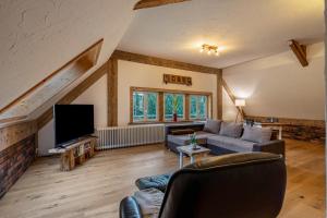 a living room with a couch and a tv at Schwarzwald Chalet - Karlshütte in Neuweg