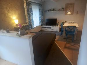 a kitchen and living room with a television and a table at Stara Stajnia Moszyce - Apartament w Dolinie Baryczy in Twardogóra
