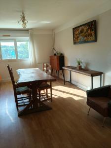 a living room with a table and a piano at Chambre d'hôte Mont mouton in Laferté-sur-Amance +5 photos