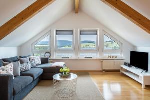 a living room with a couch and windows at Weitblick in Breitnau