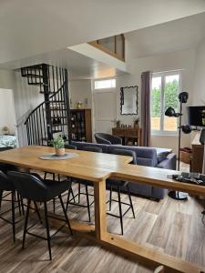 a living room with a wooden table and chairs at L'escale du Cap A in Barneville-Carteret
