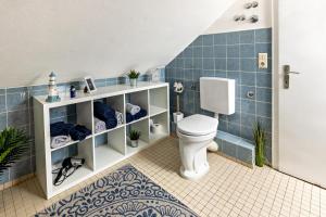 a bathroom with a toilet and a blue tiled wall at Ferienappartement Sonnenhof in Triberg +12 photos