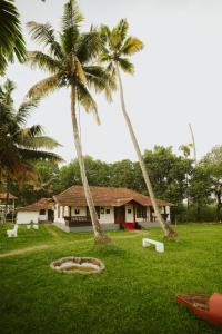 two palm trees in front of a house at Alleppey Backwater Resort in Alleppey +15 photos