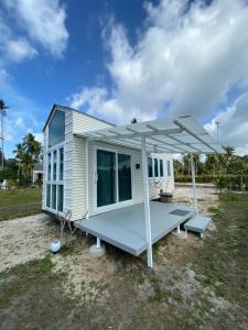 a tiny house with a porch and an umbrella at Beach Access Tiny House 06 - Lipa Noi Beach in Koh Samui