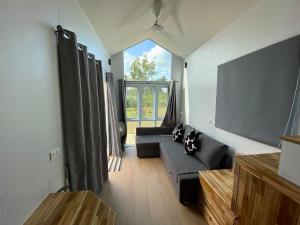 a living room with a couch and a large window at Beach Access Tiny House 06 - Lipa Noi Beach in Koh Samui