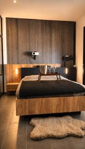 a bedroom with a large bed with a wooden wall at Jacuzzi, massage et plage ! in Fréjus +12 photos
