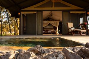 a swimming pool in front of a house with a tent at Soroi Amboseli in Amboseli
