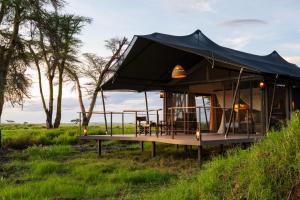 a tent with a table and chairs in a field at Soroi Amboseli in Amboseli +25 photos