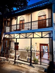 a white building with a balcony and a door at Villa Mon Cheri in Pondicherry