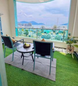 a room with two chairs and a table and a balcony at Silver Place Marina Island Lumut in Lumut