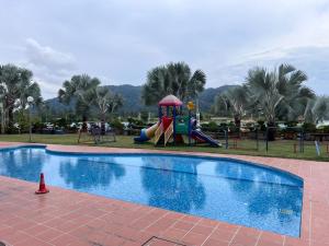 a playground with a slide next to a swimming pool at Silver Place Marina Island Lumut in Lumut
