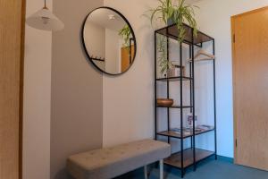 a room with a mirror and a bench and a stool at Apartment BergStyle in Pfronten