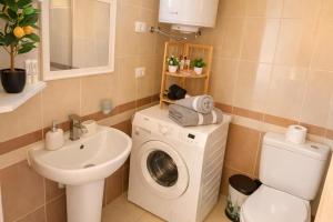 a bathroom with a washing machine and a sink at Durres Sun & Sea Luxury Apartment in Durrës