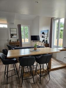 a dining room with a large wooden table and chairs at L'escale du Cap A in Barneville-Carteret