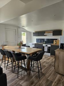 a large kitchen with a wooden table and chairs at L'escale du Cap A in Barneville-Carteret +38 photos
