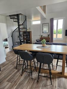 a dining room with a wooden table and chairs at L'escale du Cap A in Barneville-Carteret