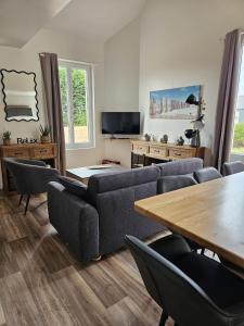 a living room with a couch and a table and chairs at L'escale du Cap A in Barneville-Carteret