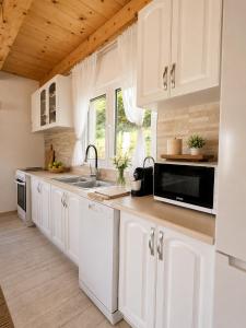 a kitchen with white cabinets and a sink at Forest Panorama Cabin Brezna in Plužine