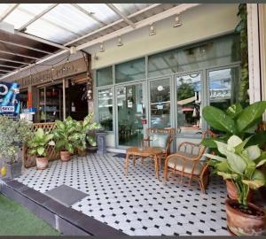 a patio with a table and chairs and plants at Tak Residence Hotel in Tak