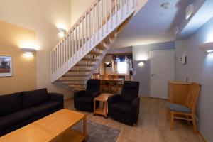 a living room with a staircase and a table and chairs at Spa Hotel Rauhalahti in Kuopio