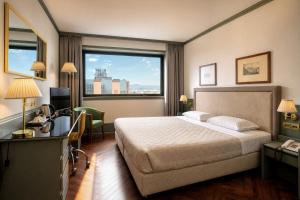 a hotel room with a bed and a desk at Ferretti Hotel Catullo Verona in San Martino Buon Albergo +30 photos