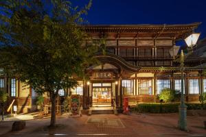 an entrance to a building with a tree in front at 緑翠-Ryokusui- in Beppu
