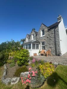 a stone house with a garden in front of it at Whinburn Guest House in Fort William